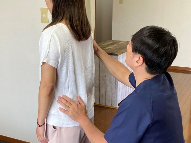 うるま市の整体院で、産後の腰痛の原因となる全身のバランスと骨盤の歪みをチェックする様子