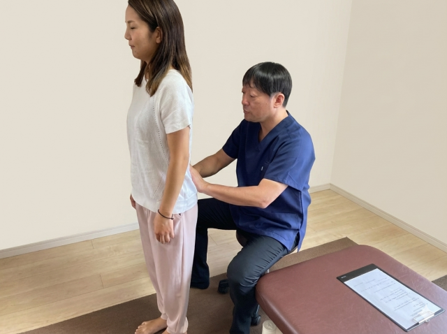 坐骨神経痛の原因となる体の歪みや動きの癖を確認する立位検査