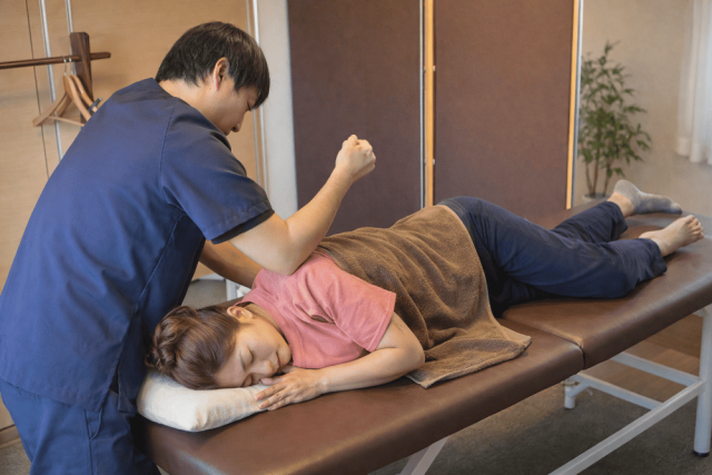 肩こり・頭痛の原因となる肩甲骨付近への施術風景。理学療法士・作業療法士の国家資格を持つセラピストが、一人ひとりの状態に合わせて丁寧にアプローチしています。