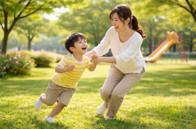 朝の公園で子どもと笑顔で遊ぶ30代の母親